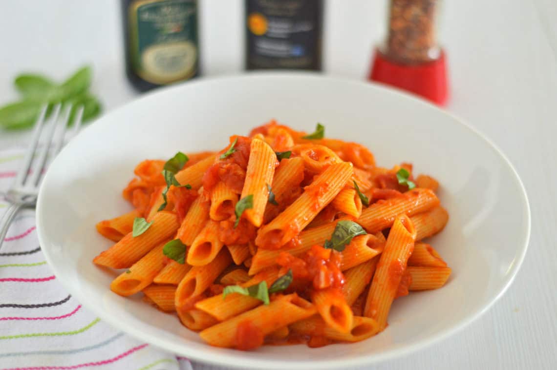 Side shot photo my Penne all'Arrabbiata recipe with basil in the background
