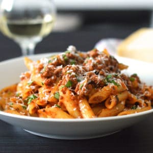 Italian Sausage Pasta in a white bowl with parmesan