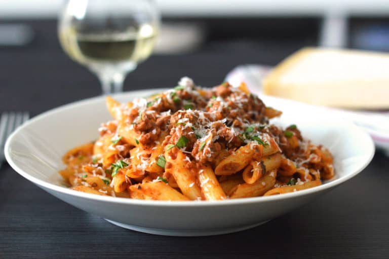 Italian Sausage Pasta in a white bowl with parmesan
