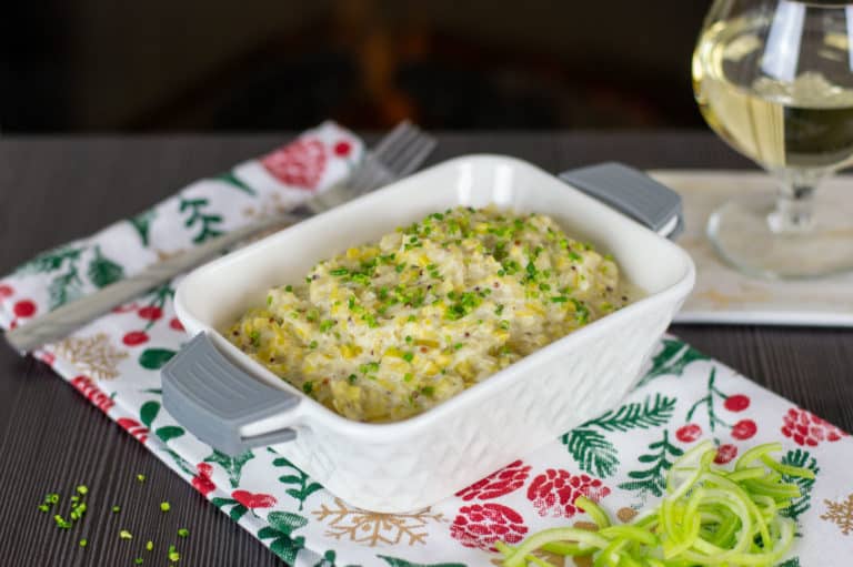 Creamed Leeks in a white dish on a Christmas table.