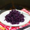 Braised Red Cabbage on a white plate next to spices