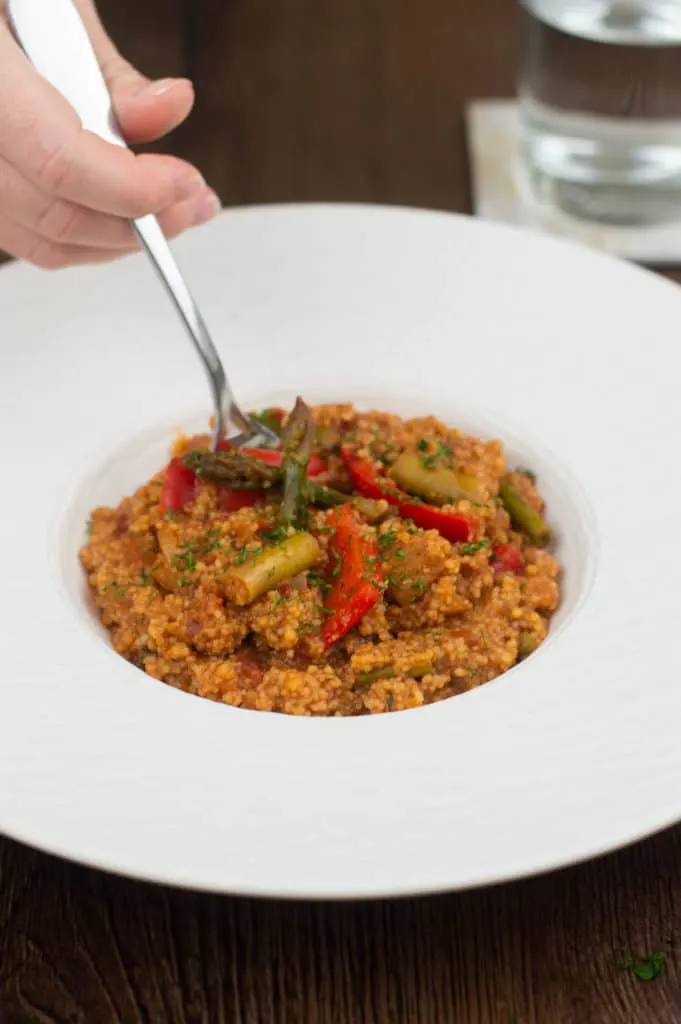 A fork digging into a bowl of moroccan couscous