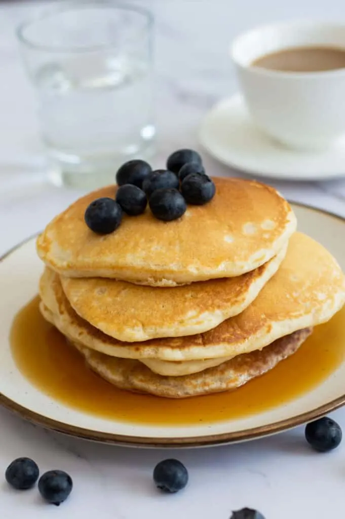 American style pancakes topped with blueberries and maple syrup