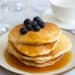 American Pancakes with blueberries with maple syrup being drizzled on top