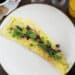 Omelette on a plate served with toast, coffee & orange juice