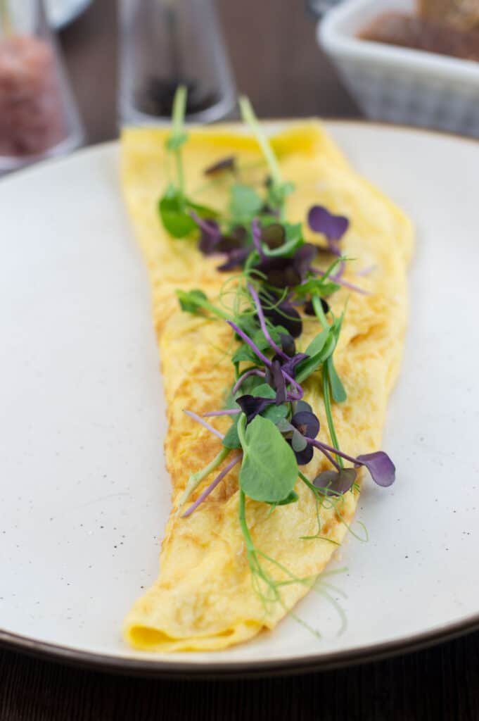 American diner style basic omelette with pea shoots & micro radish on top