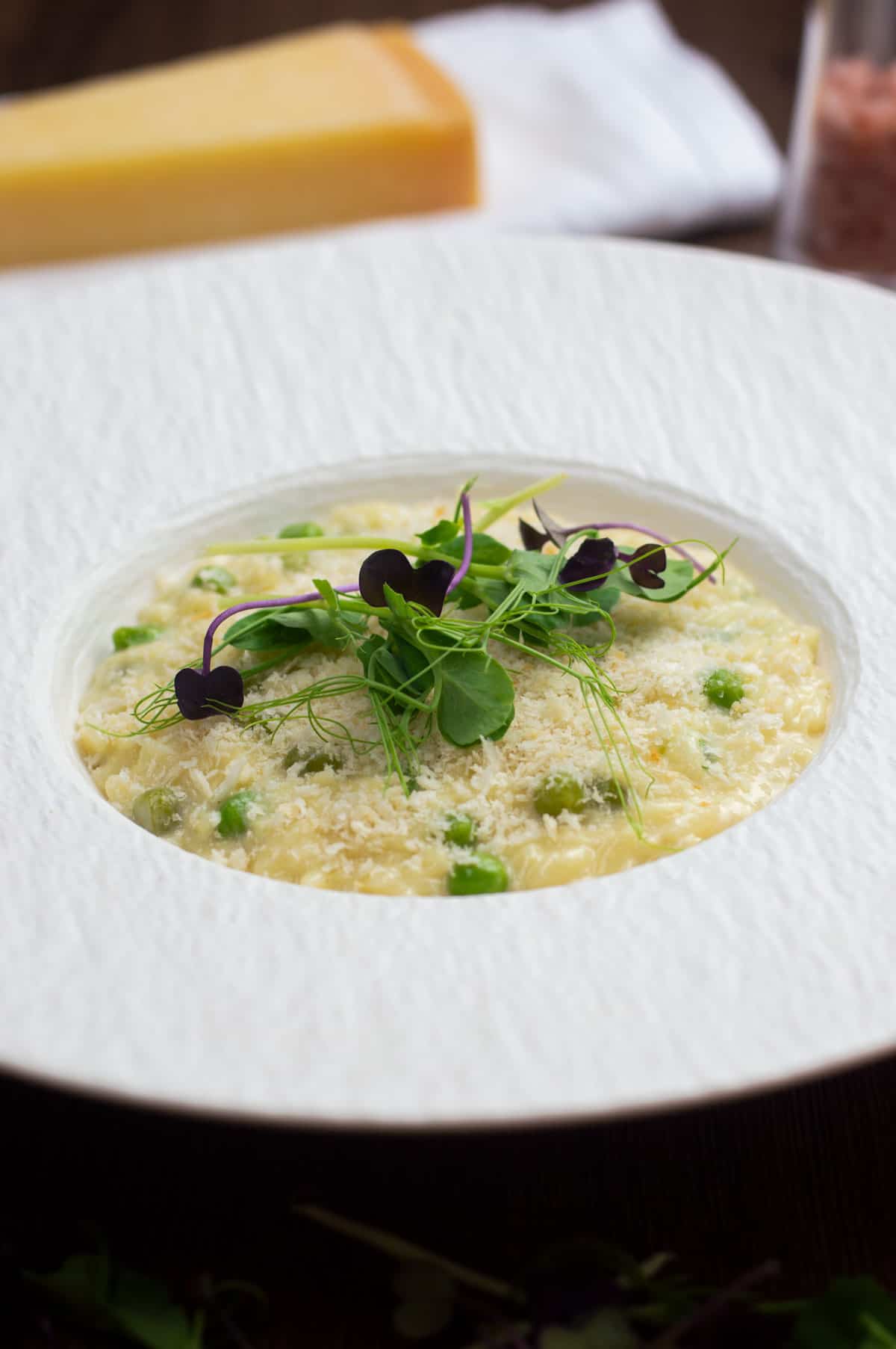 Truffle oil orzo (risoni) pasta in a white bowl with parmesan.