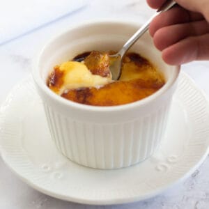 Breaking the caramel with a teaspoon on the creme brûlée