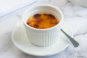 Creme brulee in a white ramkin on a small plate
