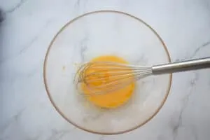 Whisked egg yolks in a glass bowl