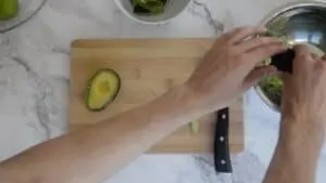 Squeezing a avocado into a mixing bowl