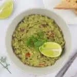 A bowl of smashed avocado with toast on the side