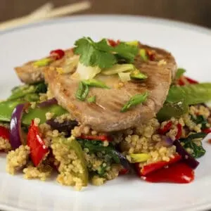 A plate of Seared Tuna steak on a pile of quinoa and stir-fried vegetables