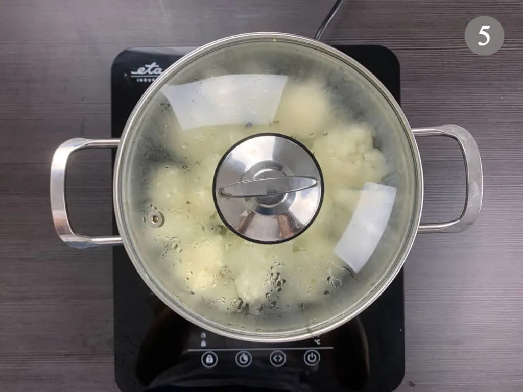 Cauliflower being boiled in a pot with the lid on