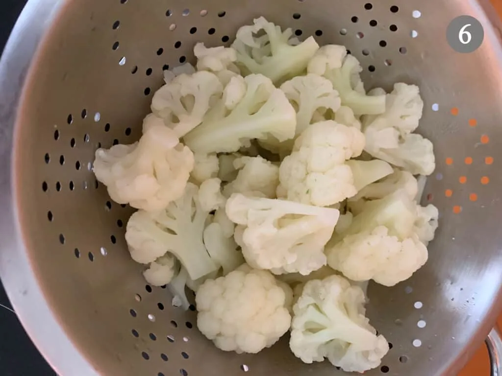 Cooked Cauliflower being drained in a colander