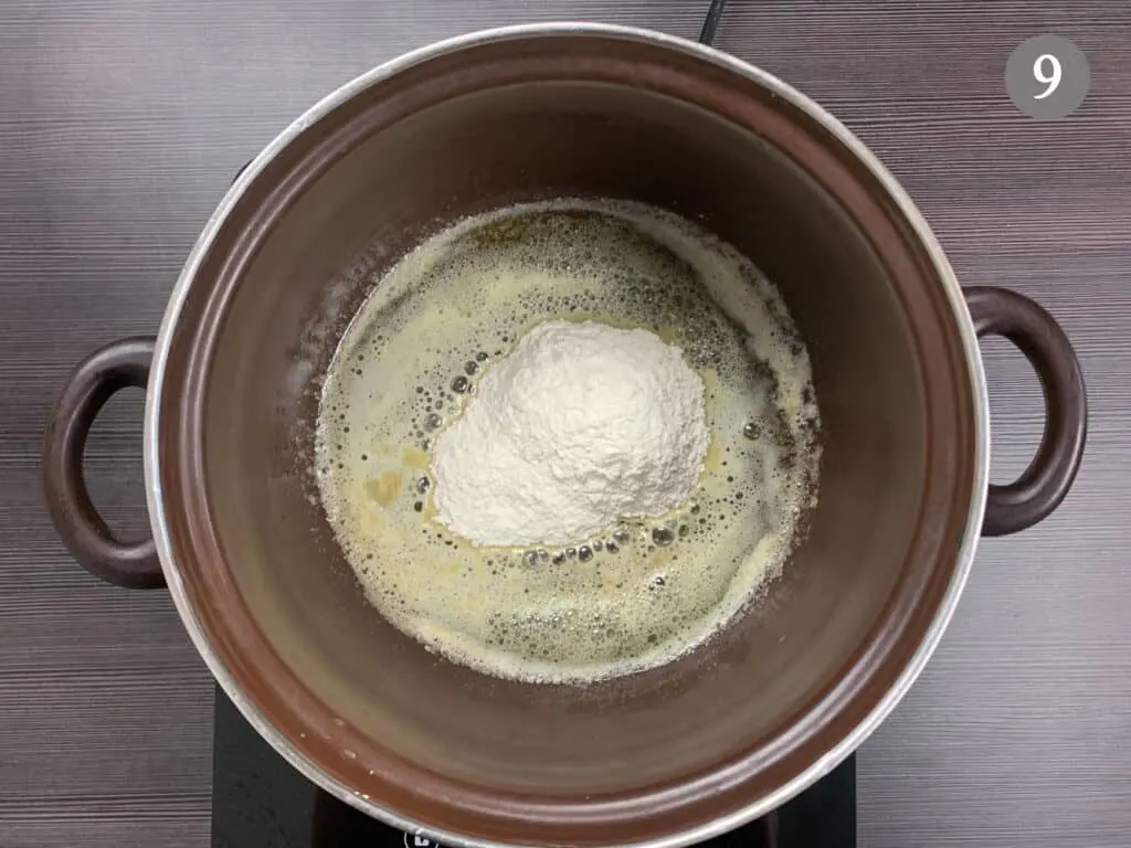 Adding flour to a pot of melted butter