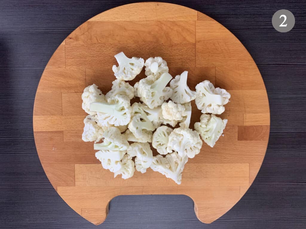 Cauliflower that has been prepped on a chopping board