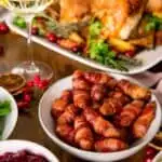 crispy pigs and blankets on a decorated Christmas dinner table
