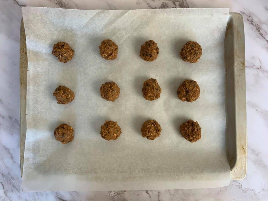 Portioning the cookie dough into balls on a baking tray