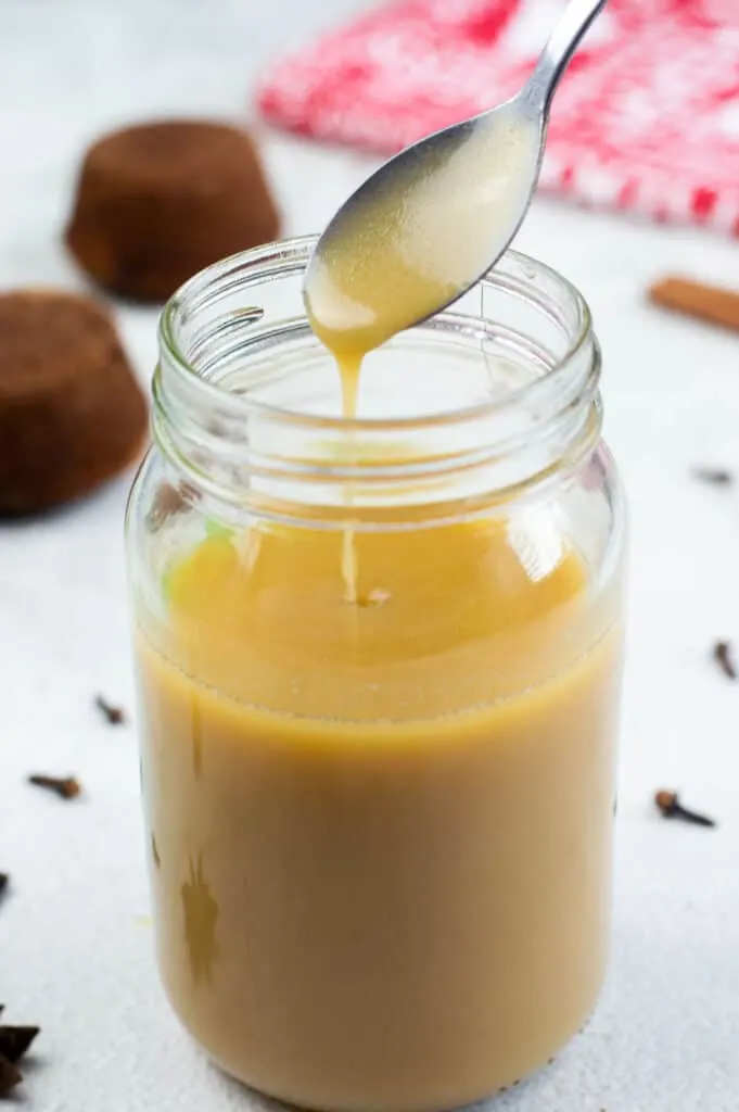 A jar of toffee sauce with a spoon
