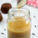 Toffee Sauce in a glass jar with spices and sticky toffee pudding in the background