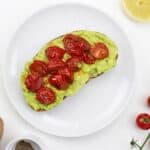 Smashed avocado on toast with roasted cherry tomatoes on top