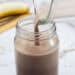 Weight Gainer Smoothie being poured into a mason jar with a sliced banana in the background
