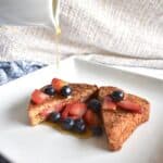 Vegan french toast with berries with a just of maple syrup drizzling on them