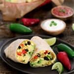 Planted based breakfast burrito cut in half on a plate