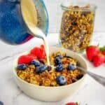 Vegan granola with a jug pouring soya milk