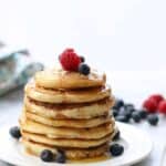 a huge stack of pancakes with berries