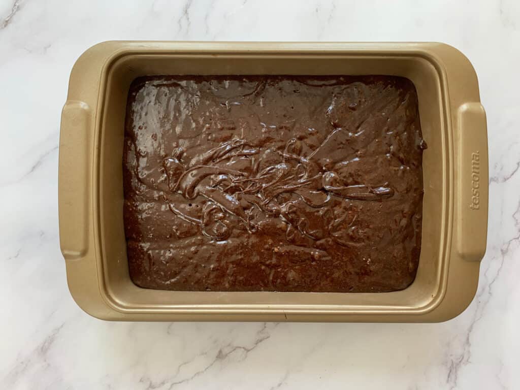 Brownie batter added to a baking tray
