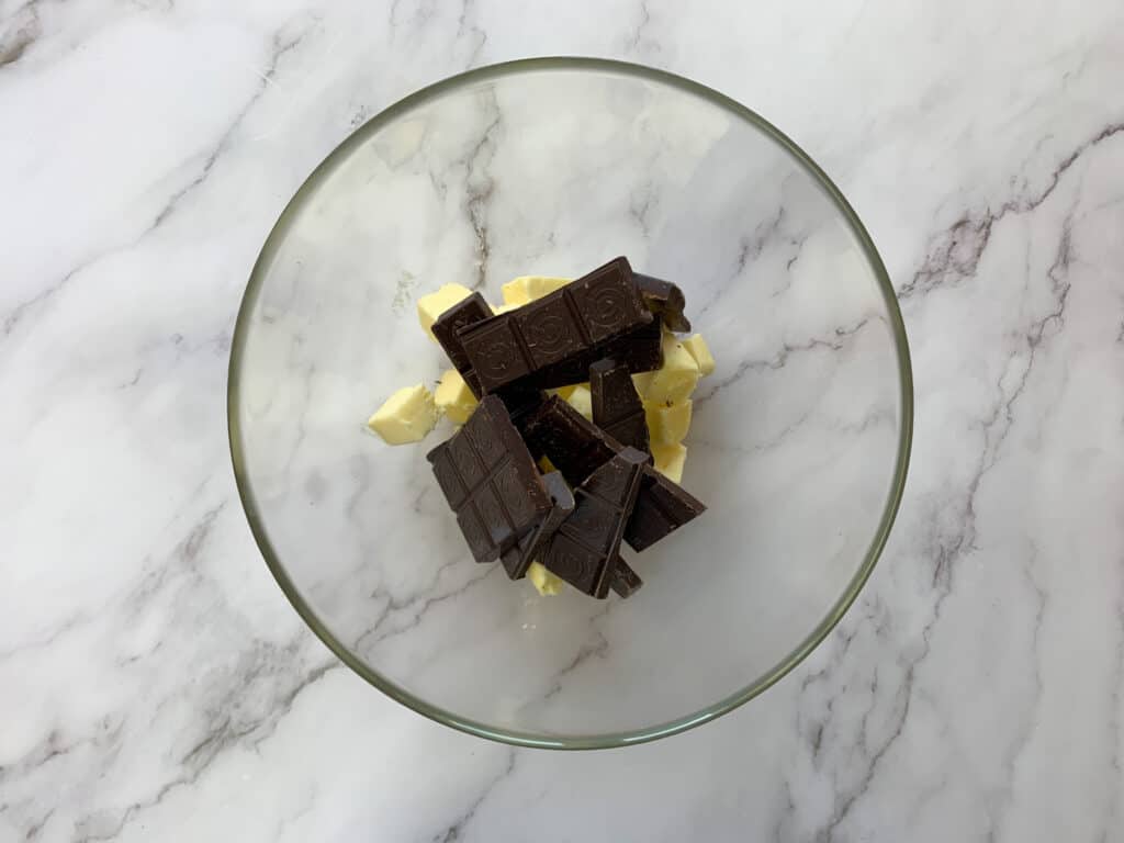 Dark chocolate and cubed butter in a glass bowl