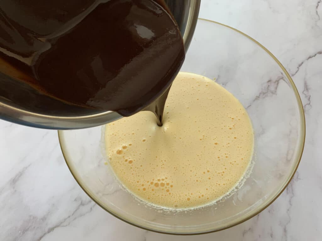 Pouring melted chocolate into whipped eggs