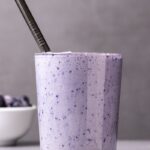 Blueberry Smoothie with fresh blueberries in the background