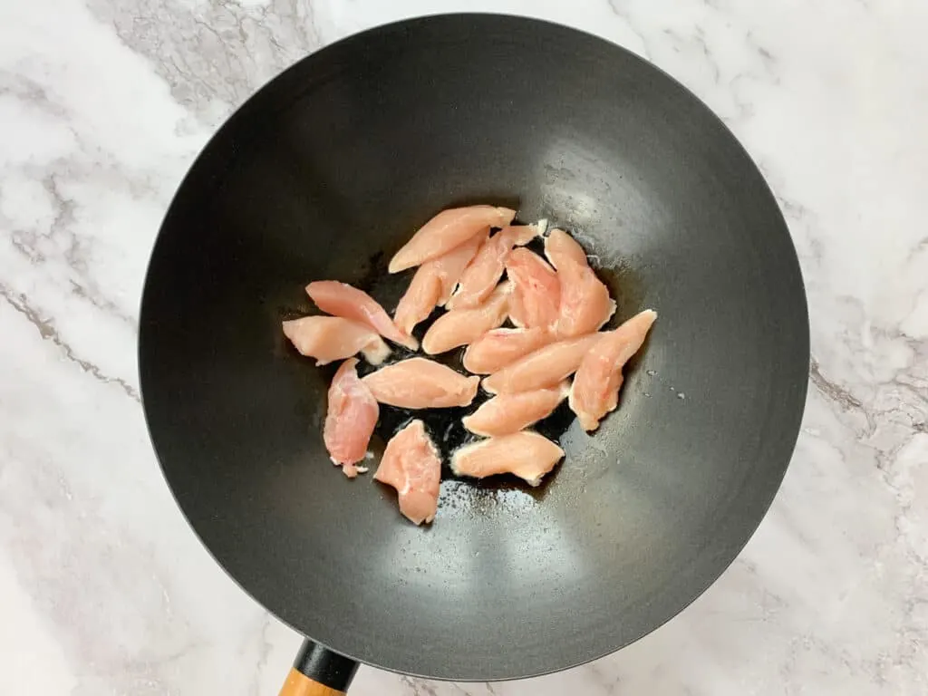 Chicken fillets being cooked in a wok