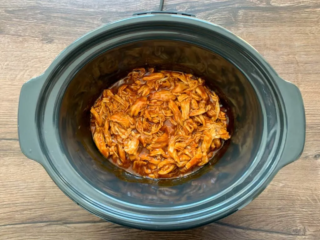 Shredded bbq chicken in a black crockpot