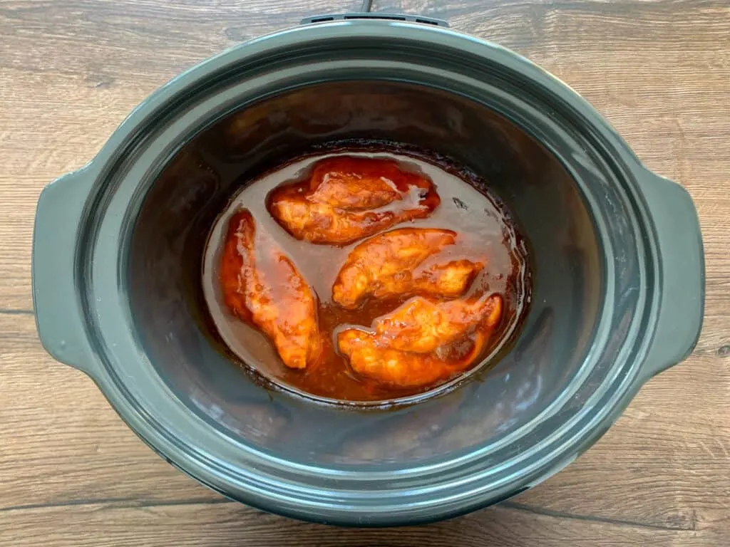 Chicken breast and bbq sauce that has been cooked in the crockpot