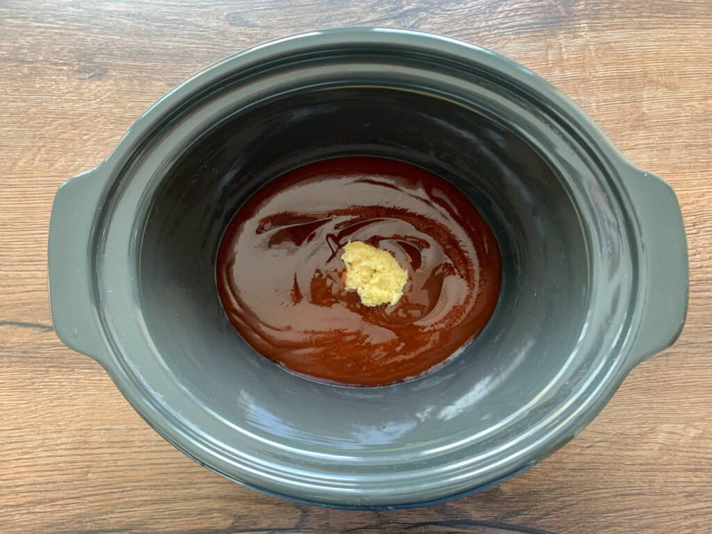 bbq sauce and a heap of minced garlic in a crock pot