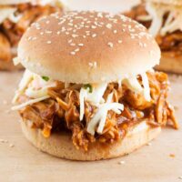 Crockpot cooked bbq chicken in a seeded burger bun with coleslaw