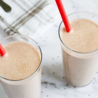 two vegan keto smoothies in a glass with a red straw