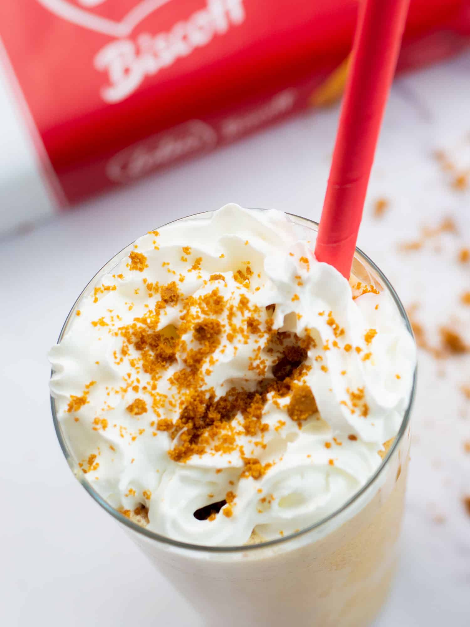 Biscoff milkshake in a tall glass and a red straw