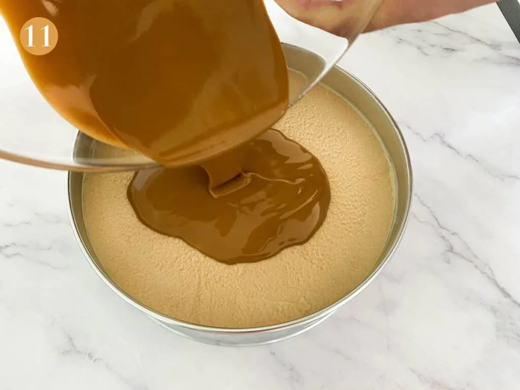 Pouring melted biscoff spread onto a cheesecake