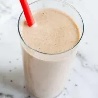 Vegan keto smoothie in a tall glass with a red straw