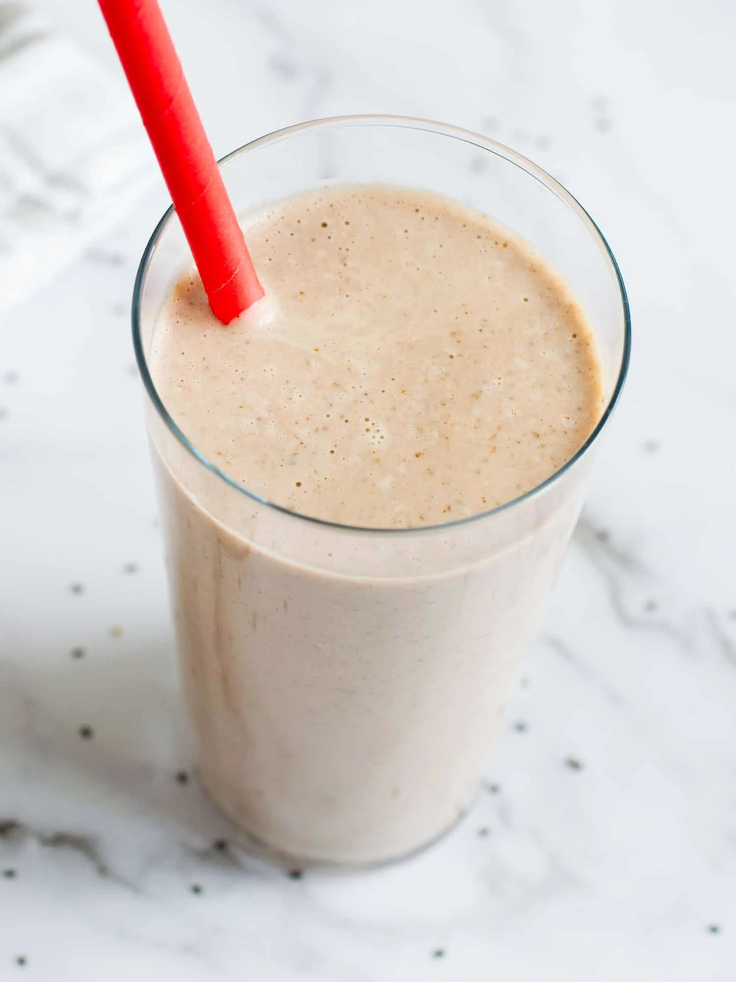 Vegan keto smoothie in a tall glass with a red straw