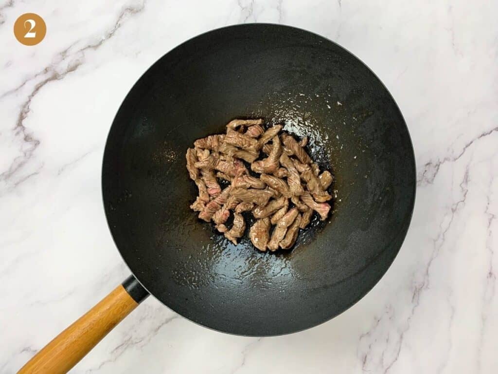 Seared beef steak in a large wok