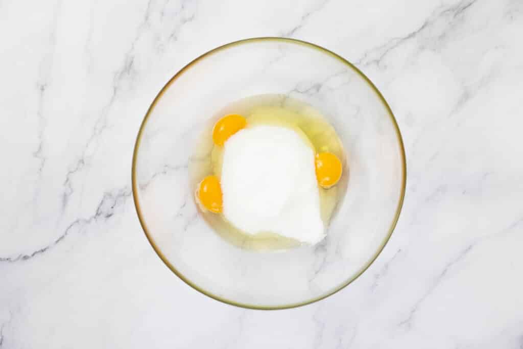 Eggs and sugar in a large glass bowl