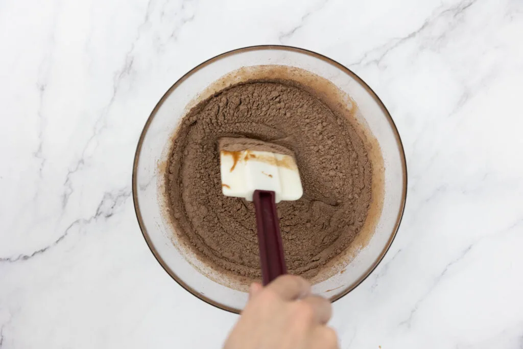 Folding flour and cocoa mixture into whipped eggs and sugar