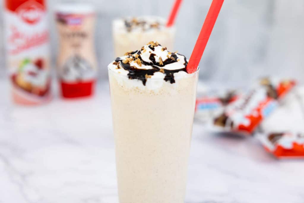 Kinder Bueno milkshake in a tall glass with a red straw