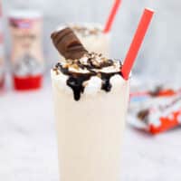 Kinder Bueno milkshake in a tall glass with a red straw